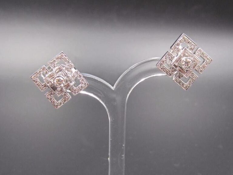 PAIRE de BOUCLES D’OREILLES carrées en or gris (750 millièmes) ajouré à motifs géométriques, serti de diamants baguettes et taille brillant dont un, au centre, plus importan