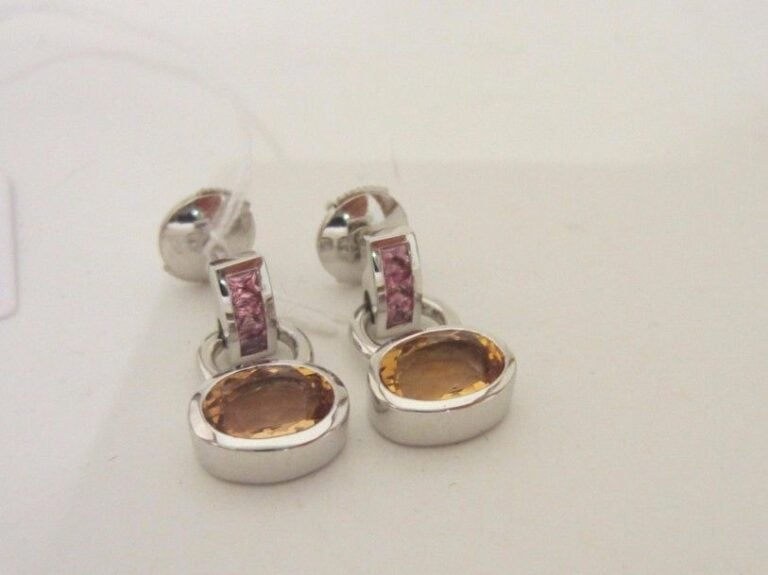 PAIRE de BOUCLES D’OREILLES en or gris (750 millièmes) articulé serti de saphirs roses calibrés retenant une topaze jaune de forme ovale en serti clo