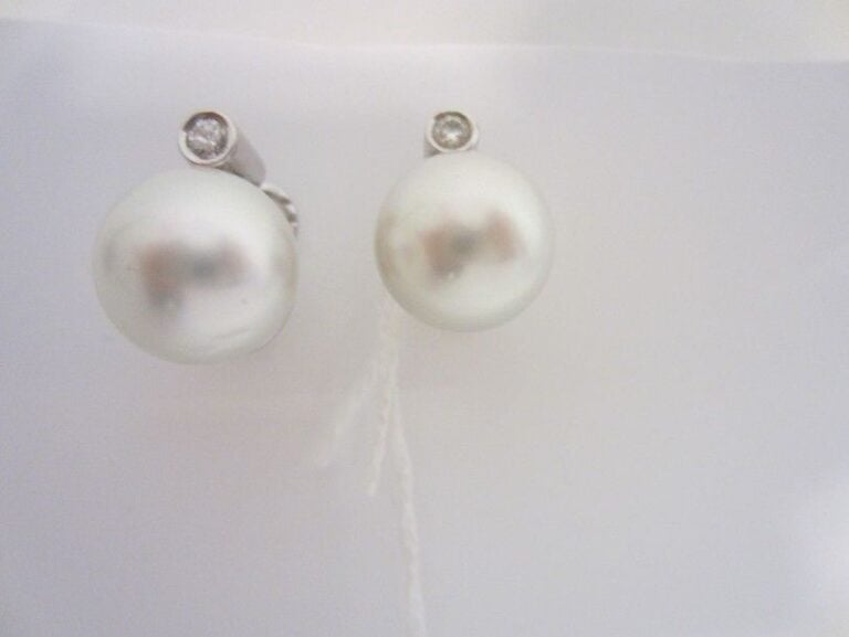 PAIRE DE BOUCLES D?OREILLES en or gris (750 millièmes) serti d?une perle de culture blanche légèrement bouton et d?un diaman
