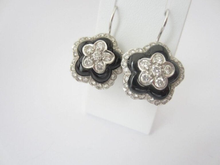 PAIRE DE BOUCLES D?OREILLES «fleurs» bombés en or gris (750 millièmes) serti de diamants taille brillant alterné d?onyx, le fermoir en col de cygn