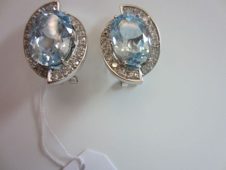 PAIRE DE BOUCLES D?OREILLES ovales en or gris (750 millièmes) serti de deux topazes bleues soulignées de diamant