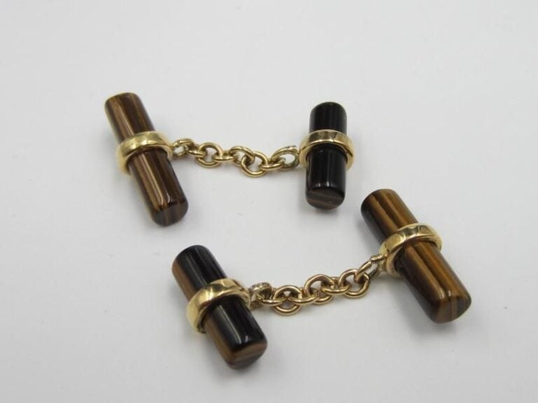 PAIRE de BOUTONS DE MANCHETTE en or jaune (750 millièmes) orné de deux bâtonnets de quartz oeil-de-tigr