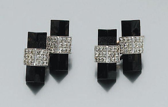 Paire de BOUTONS DE MANCHETTES « bâtonnets », en platine et or rose, serti d'onyx taillé à base triangulaire rehaussé de pavages de diamant