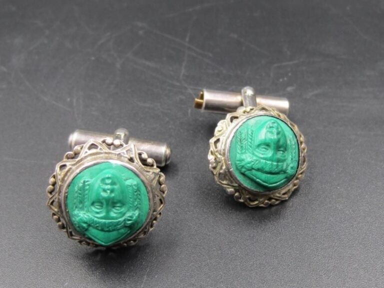 PAIRE DE BOUTONS DE MANCHETTES en métal ajouré, orné de camées de malachite représentant un visage d'inspiration égyptienne