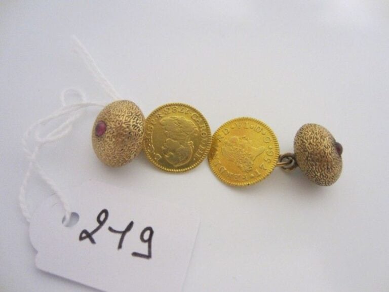 PAIRE de BOUTONS de MANCHETTES en or jaune (750 millièmes), ciselés, composé d?une boule sertie d?un grenat cabochons et de pièces espagnole