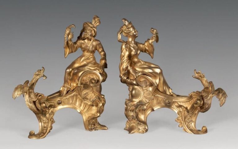 Paire de chenets en bronze ciselé et doré; ils représentent un couple de chinois tenant sur une main un perroquet, ils sont assis sur une terrasse rocaille à enroulements et feuilles d'acanthe, deux dragons leur faisant vis-à-vi