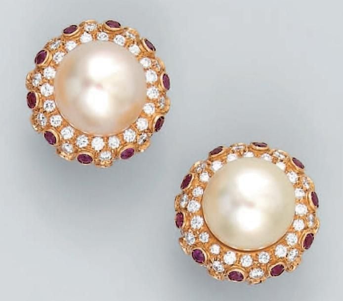 PAIRE de CLIPS D'OREILLES circulaires en or jaune serti d'une importante perle de culture blanche, légèrement bouton, entourée de diamants taille brillant et de rubis ronds en serti clo
