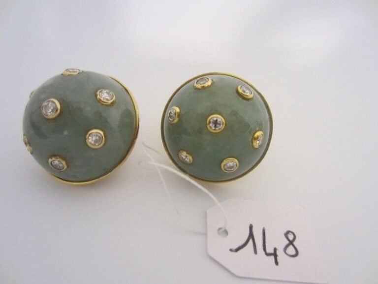 PAIRE DE CLIPS D?OREILLES circulaires en or jaune (750 millièmes) serti d?un cabochon de jade flanqué de diamants en serti clo
