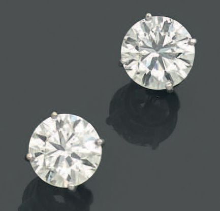 PAIRE de CLOUS D'OREILLES en or gris (750 millièmes) serti chacun d'un diamant demi-taill
