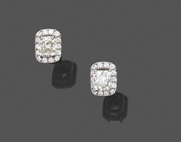 •Paire de CLOUS D'OREILLES en or gris (750‰) serti d'un diamant taille coussin entouré de diamants taille brillan