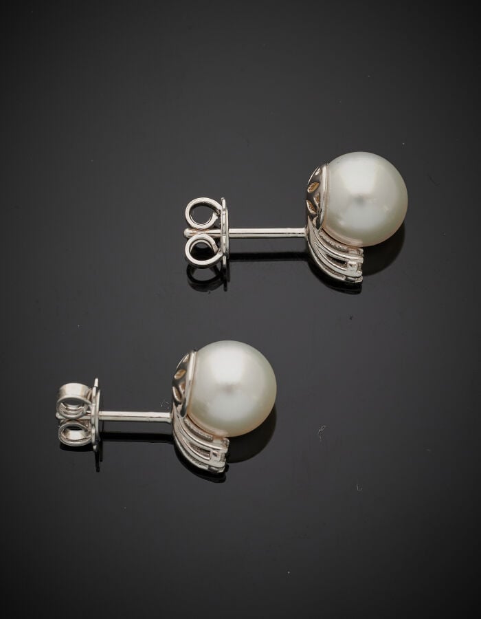 Paire de CLOUS d'OREILLES en or gris (750‰) serti de diamants et orné d'une per…
