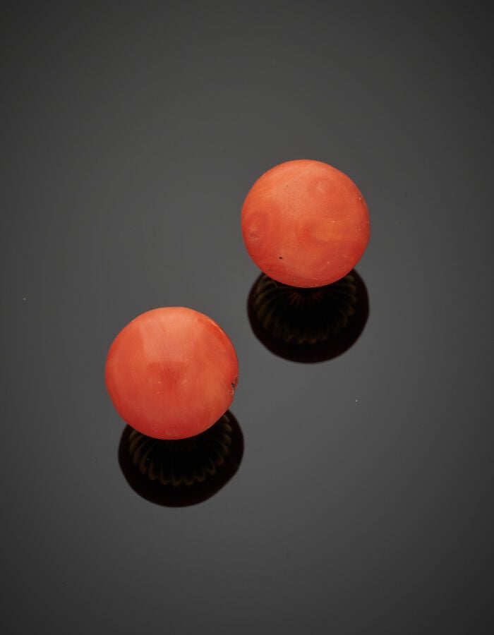 Paire de CLOUS d'OREILLES en or jaune (750‰) orné de corail de forme bouton. Lé…