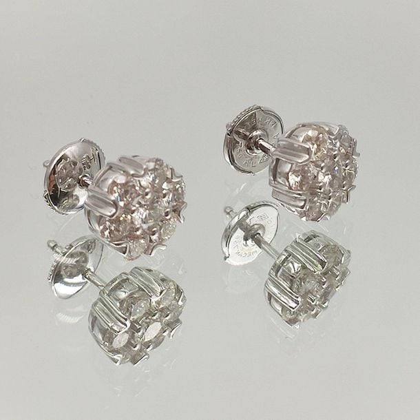 •Paire de CLOUS d'OREILLES «fleurettes» en or gris (750‰) serti de sept diamants taille brillan