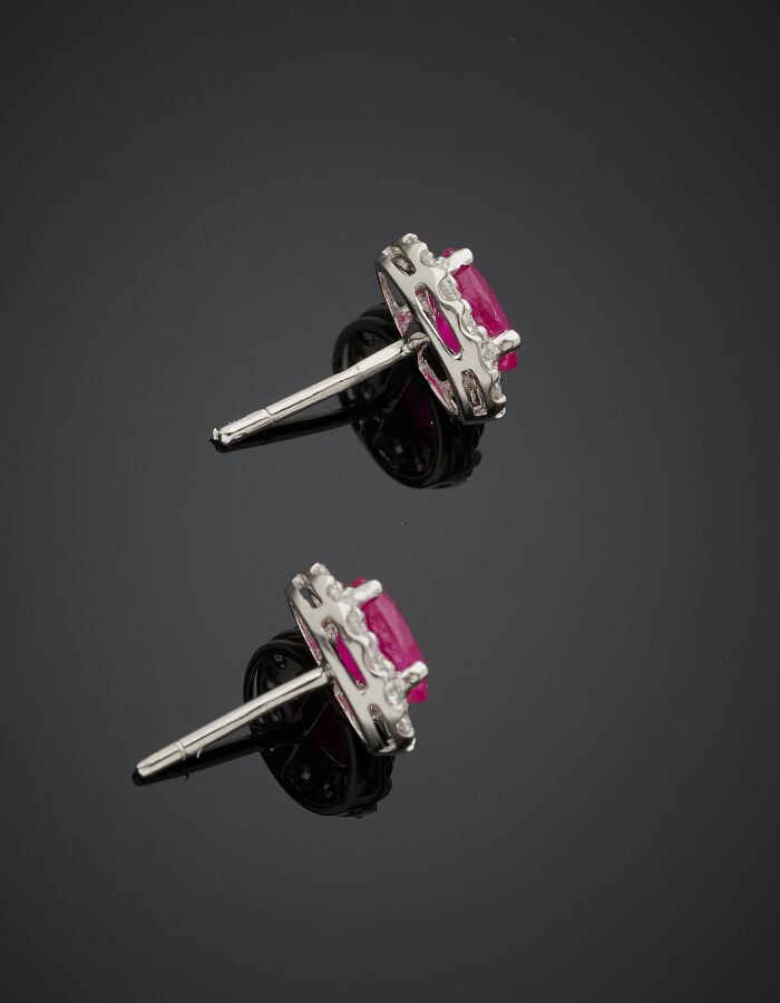 Paire de CLOUS d'OREILLES ovales en or gris (750‰) serti chacun d'un rubis pesa…