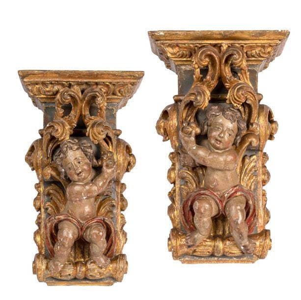 Paire de consoles d'appliques en bois sculpté polychrome et doré à décor d'angelots en haut relief et feuilles d'acanth