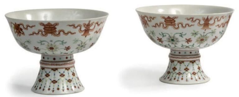 Paire de coupes sur piédouche en porcelaine et émaux corail et polychrome, à décor de lotus et emblèmes bouddhique