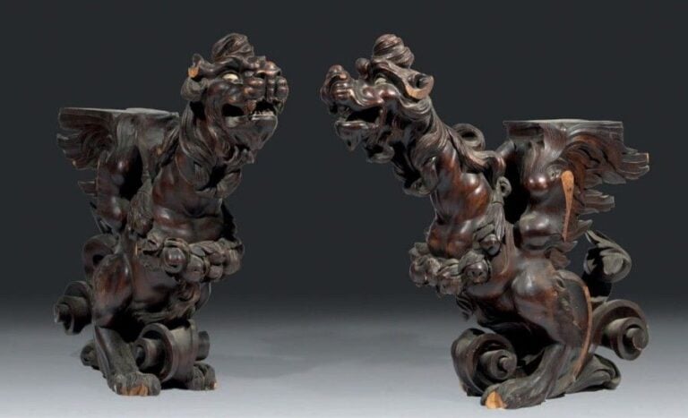 Paire de dragons en résineux sculpté et patiné; ils sont représentés la gueule entre-ouverte et reposant sur de larges volute