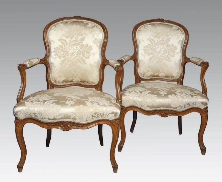 PAIRE DE FAUTEUILS à dossier cabriolet en hêtre mouluré et sculpté de fleurs ; ceintures chantournées nervurées à bouquet