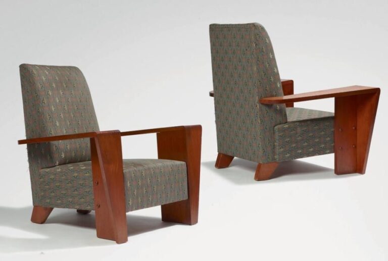 Paire de fauteuils en acajou Très rare et importante paire de fauteuils en acajou d'une esthétique très aérodynamique présentant des accoudoirs en forme d'équerres dont la face avant s'affine en direction du so