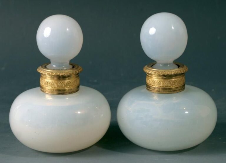 Paire de flacons boules et leurs bouchons en opaline de cristal savonneuse; monture de col en bronze doré ciselé (fêlure sous une monture