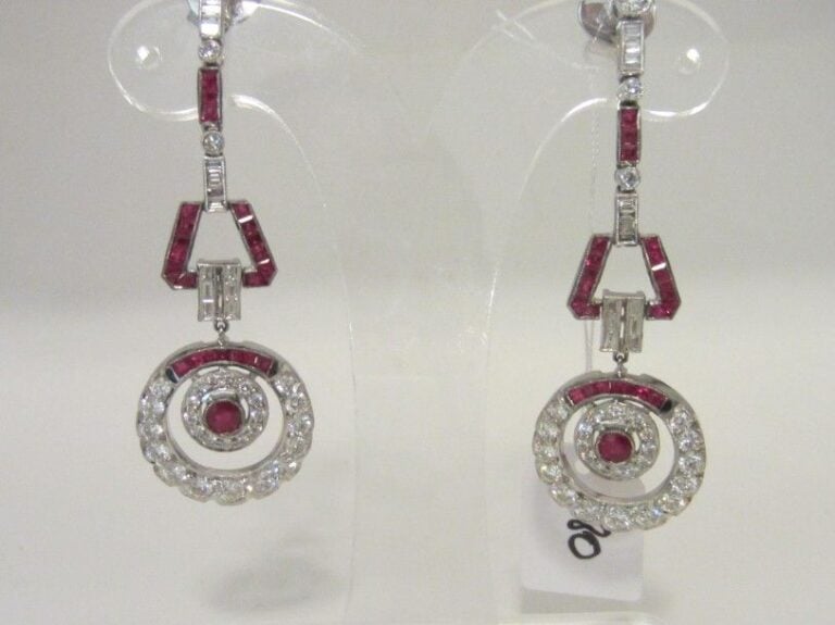 PAIRE de longs PENDANTS D'OREILLES à motifs géométriques et circulaire, en or gris (750 millièmes) articulé et ajouré, serti de diamants taille brillant, baguettes et rubis calibré