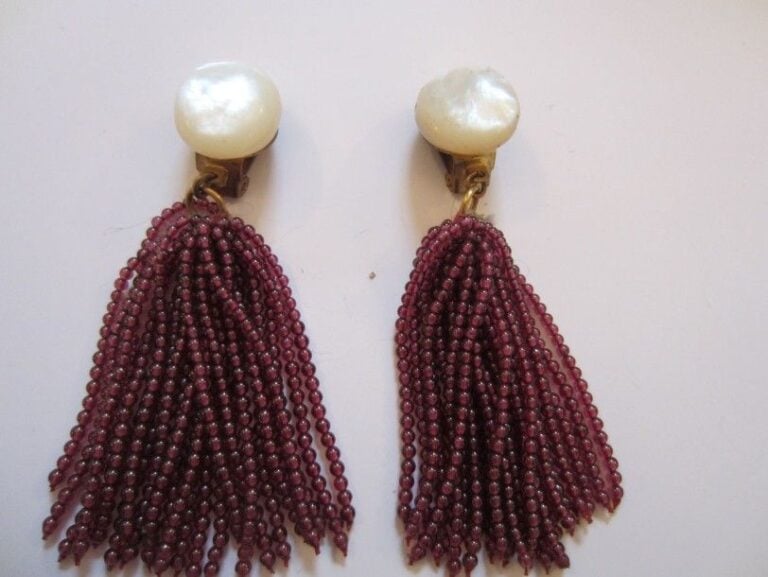 PAIRE DE PENDANTS D'OREILLES en métal orné de nacre et retenant un pompon de perles de grena