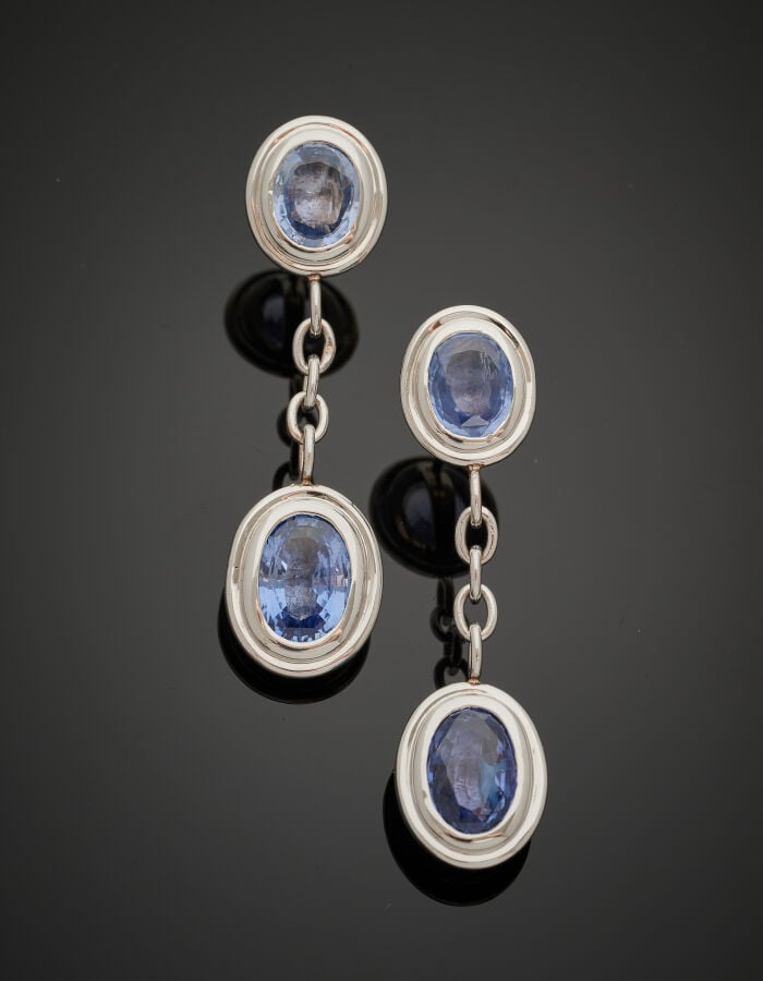 Paire de PENDANTS d'OREILLES en or gris (750‰) godronné, serti de deux saphirs…