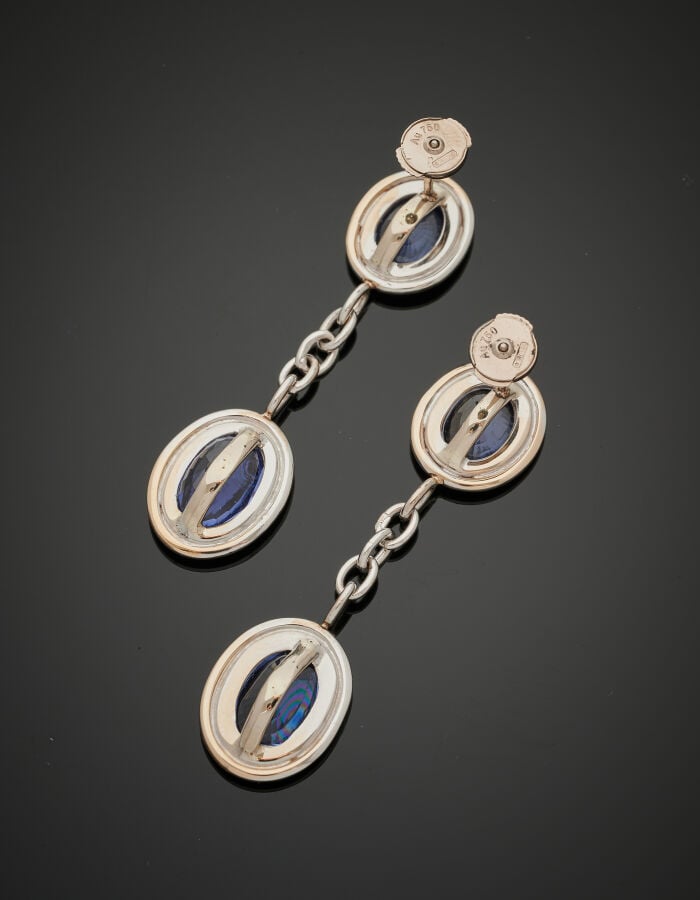 Paire de PENDANTS d'OREILLES en or gris (750‰) godronné, serti de deux saphirs…