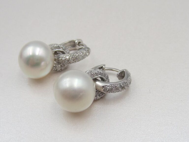 Paire de PENDANTS D'OREILLES en or gris (750 millièmes) à motifs d'anneaux entrelacés pavés de diamants taille brillant, retenant une perle de culture blanch