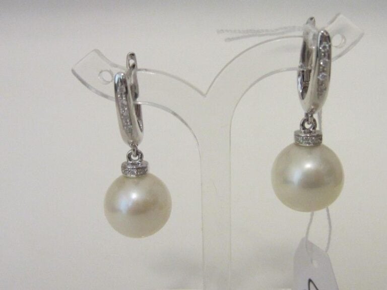 PAIRE DE PENDANTS D'OREILLES en or gris (750 millièmes) serti d'une perle de culture surmontée de lignes de diamant