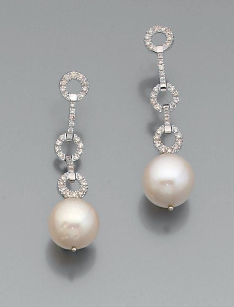 PAIRE de PENDANTS D'OREILLES en or gris articulé à motifs circulaires serti de diamants de taille brillant retenant chacun une perle de culture blanch