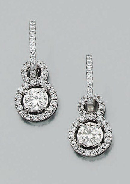 Paire de PENDANTS D'OREILLES en or gris articulé et ajouré serti de diamants de taille brillant, dont un au centre plus importan