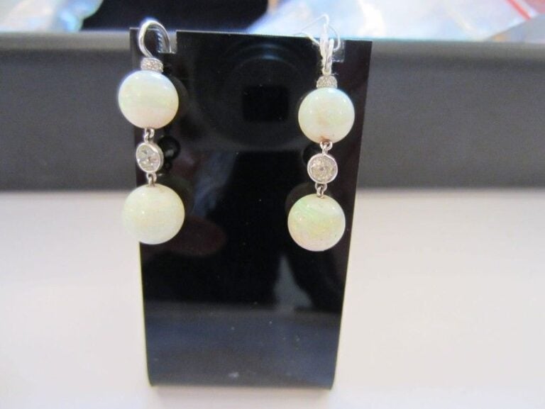 PAIRE DE PENDANTS D'OREILLES en or gris orné de deux perles d'opale séparées par un diamant taille ancienne en serti clo