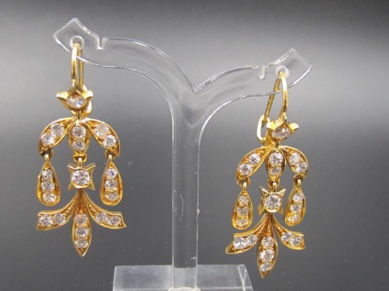 PAIRE de PENDANTS D'OREILLES en or jaune (750 millièmes) articulé à motifs «feuilles» serti de diamants taille brillan