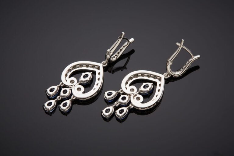Paire de PENDANTS d'OREILLES « volutes » en or gris (750‰) ajouré, serti de dia…