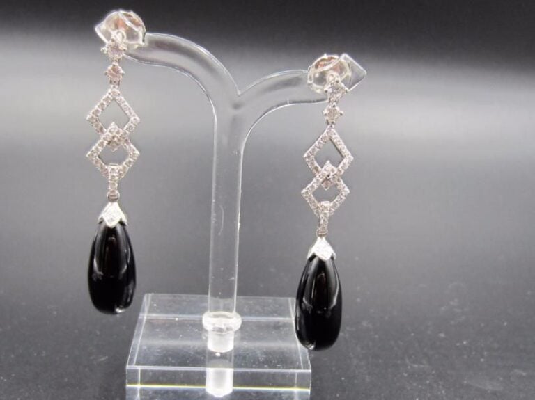 PAIRE de PENDANTS D’OREILLES en or gris (750 millièmes) ajouré à motifs de losanges serti de diamants taille brillant retenant une goutte d’onyx             Long        : 4,5 cm        Poids brut : 8,2 g