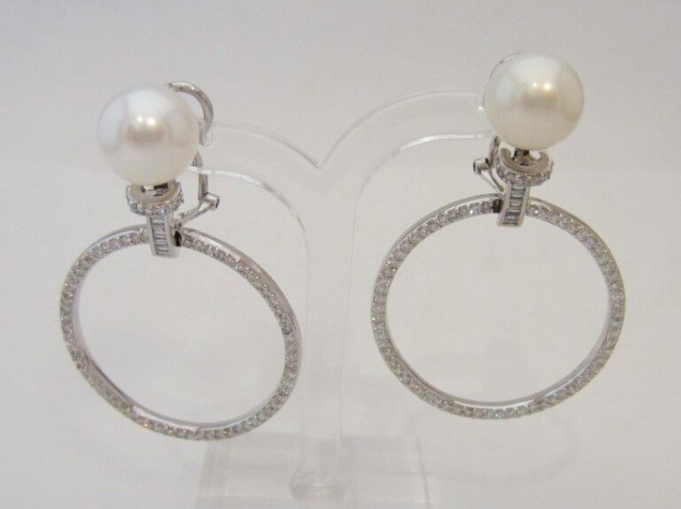 PAIRE de PENDANTS D’OREILLES en or gris (750 millièmes) ajouré orné d’une perle de culture blanche et diamants baguettes retenant un anneau serti de diamants taille brillan
