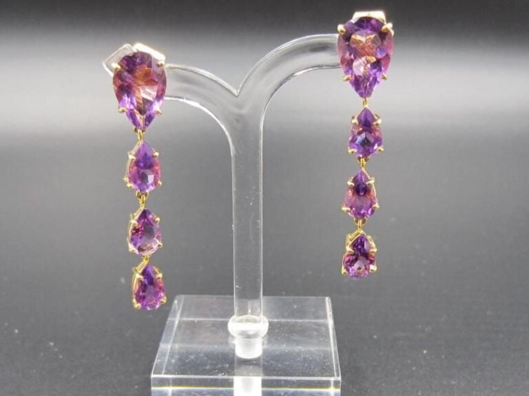 PAIRE de PENDANTS D’OREILLES en or jaune 14 carats (750 millièmes) articulé serti d’un alignement d’améthystes de forme poire dont une, plus importante             Long        : 4 cm        Poids brut : 7,6 g