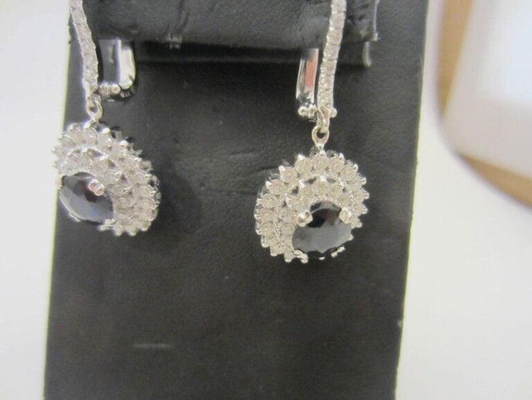 PAIRE DE PENDANTS D’OREILLES «marguerite» en or gris (750 millièmes) serti d’un saphir ovale dans un double entourage de diamants taille brillant