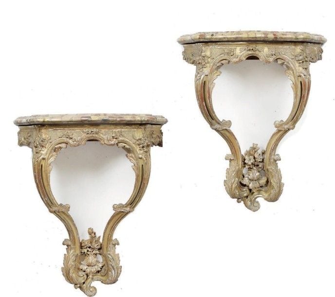 Paire de petites consoles d'appliques en bois sculpté et doré; de forme contournée, les traverses à décor de fleurs et feuillages sur fonds quadrillé