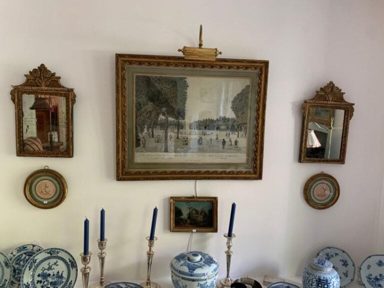 Paire de petits miroirs en bois doré sommés de fleurs sculptée