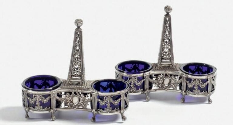 PAIRE DE SALIÈRES DOUBLES en argent à décor ajouré figurant des chérubins jouant de la trompe, des guirlandes fleuries et des entrelacs feuillagés; la prise centrale en colonn