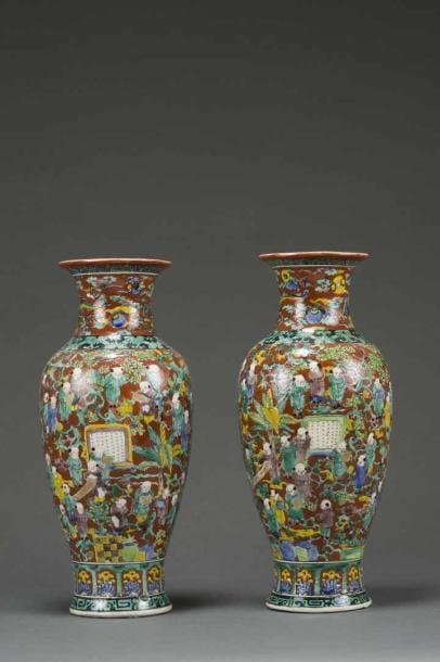 PAIRE DE VASES DE FORME BALUSTRE EN PORCELAINE DE KUTANI DANS LE GOUT D'AOKI MOKUBEI Japon, Ere Meiji-Taisho Orné d'un riche décor émaillé sur fond rouge de multiples enfants s'animant parmi des pins et des bananiers ; aux cols, des dragons lovés volants à la poursuite de la perle flammé