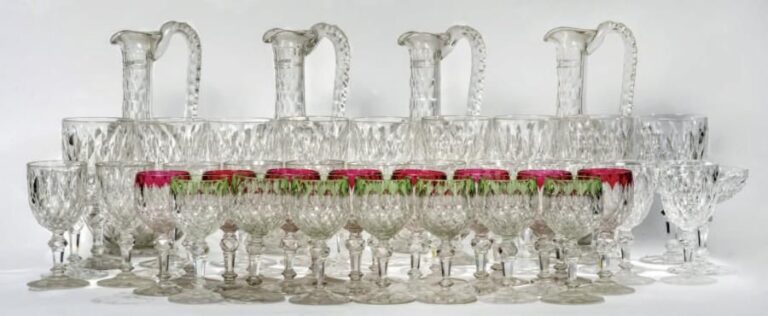 Partie de service de verres en cristal taillé comprenant 9 verres à eau, 10 coupes à champagne, 15 verres à vin en cristal transparent, 7 verres à vin en cristal à bordure verte, 9 verres à vin en cristal à bordure rouge, 4 carafes