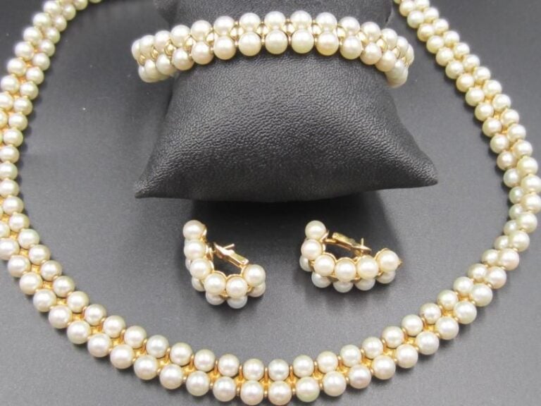 PARURE comprenant un COLLIER, un BRACELET et une PAIRE de BOUCLES D'OREILLES en or jaune (750 millièmes) bombé, composée d'alignements de perles de culture blanche