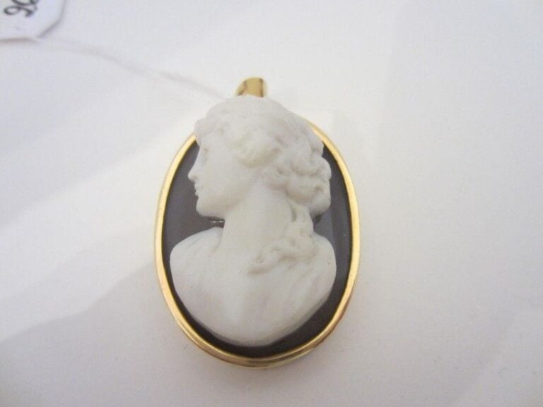 PENDENTIF BROCHE ovale en or jaune (750 millièmes) ciselé serti d’un camée buste de femme de calcédoine grise