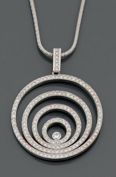PENDENTIF circulaire, en or gris 14 carats (585 millièmes) composé de quatre cercles concentriques, entièrement serti d'alignements de diamants taille brillant dont un, au centre, plus importan
