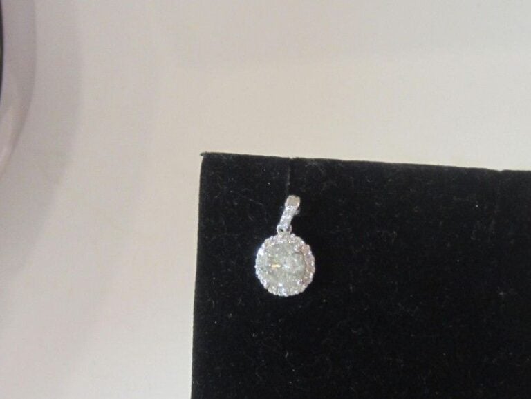 PENDENTIF circulaire en or gris (750 millièmes) serti de diamant taille brillant, dont un au centre plus important pesant 1,3 carat environ