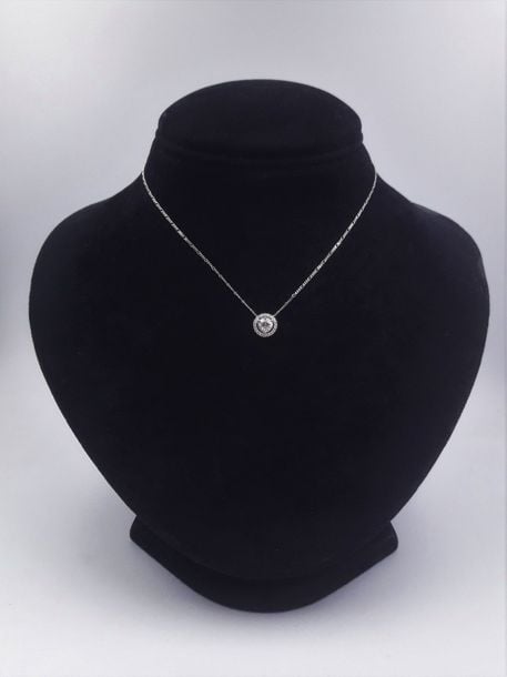 PENDENTIF circulaire en or gris (750 millièmes) serti un diamant taille ancienne, entouré de diamants taille brillan