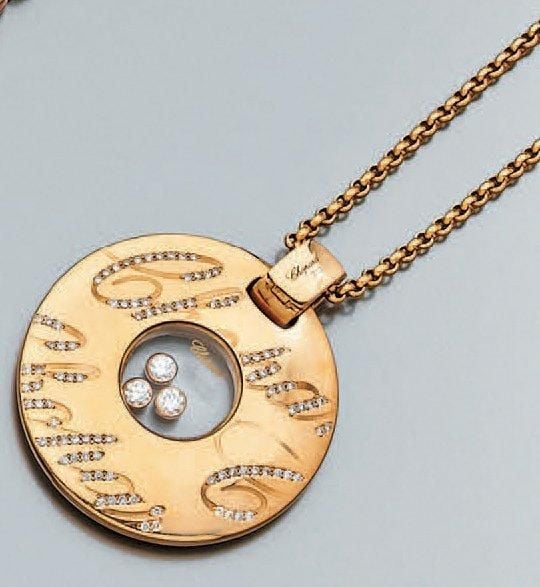 PENDENTIF circulaire en or rose, et sa chaînette, partiellement serti de diamants taille brillant portant l'inscription Chopar